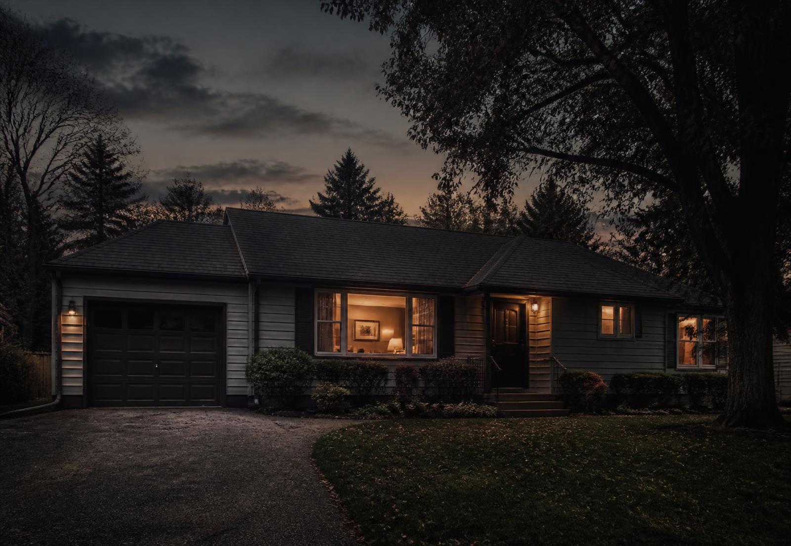 A home at dusk with warm light in the windows